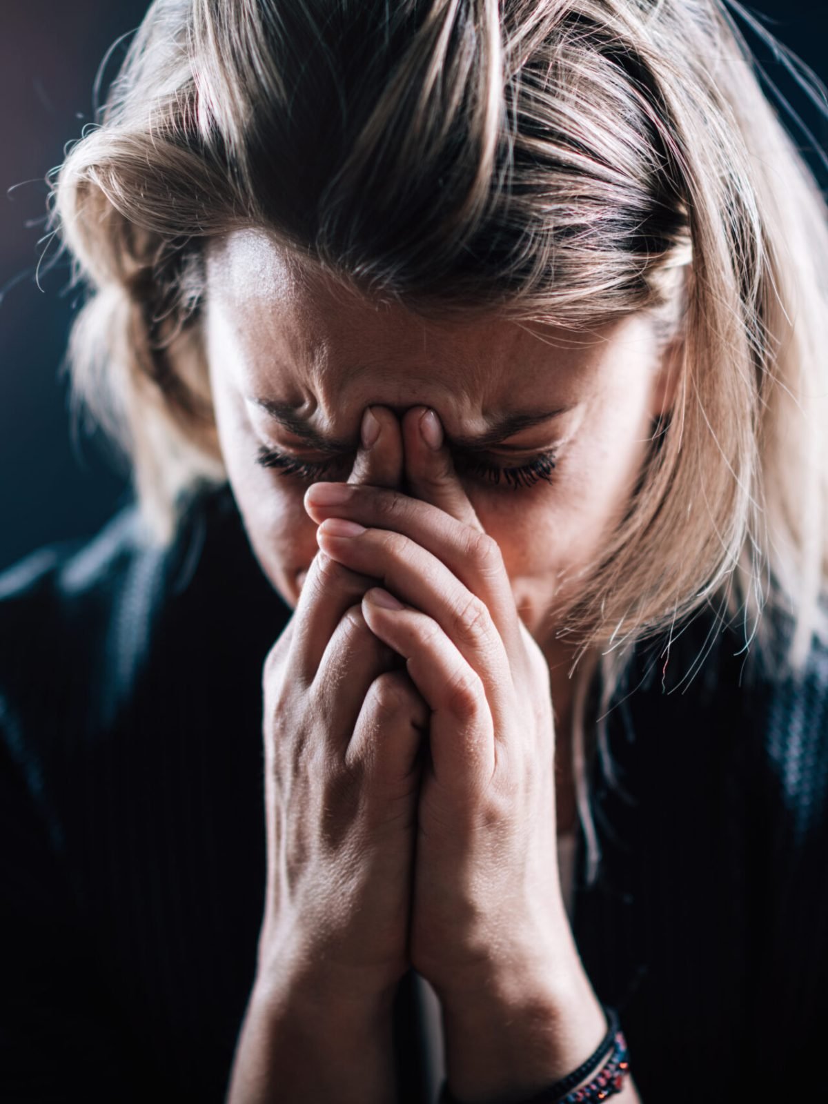Anxious female face, portrait on a dark background